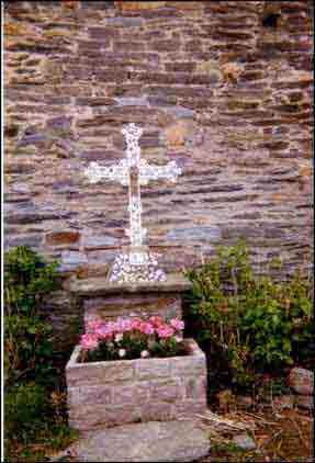 C’est une croix de fonte posée sur un socle en maçonnerie ; au centre de cette croix, figure la Vierge Marie présentant l’Enfant Jésus